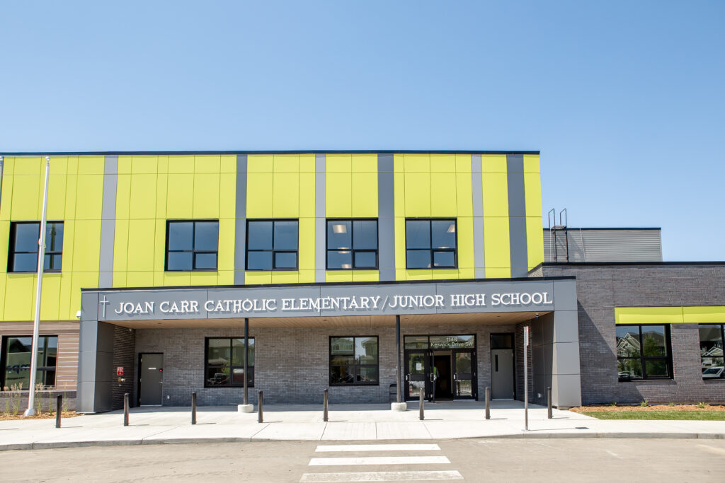 The exterior of Joan Carr Catholic Elementary / Junior High School features bright yellow with grey accents.