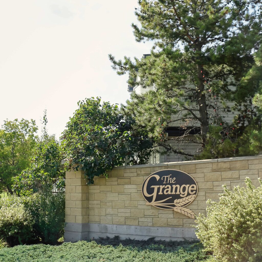 The Grange sign on a stone wall