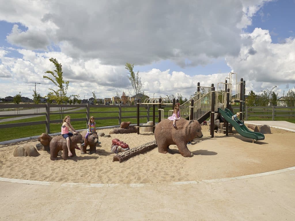Kids ride on bear statues in a wildlife themed playground