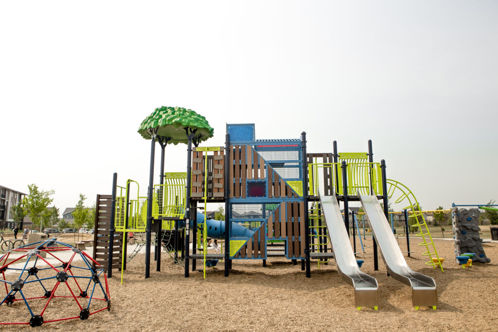A playground with two slides and treetop theme